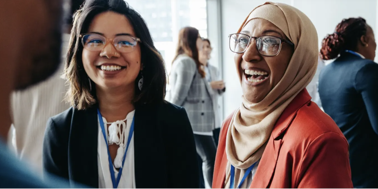 Two attendees laughing together at an Adobe networking event